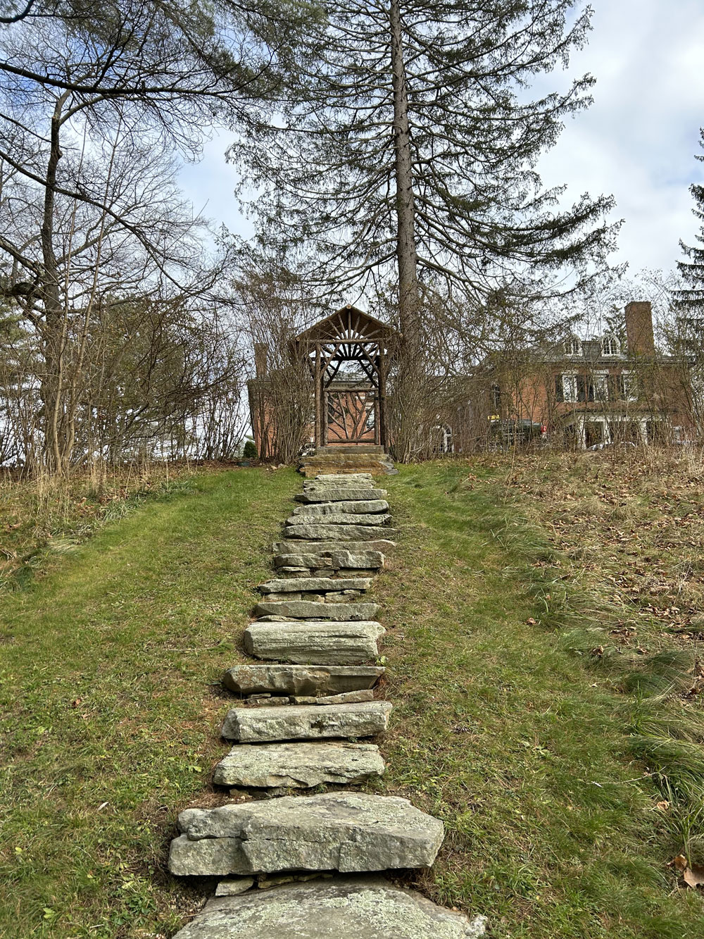Rustic garden arbor built using bark-on trees and branches titled the Dempsey Arbor and Gate
