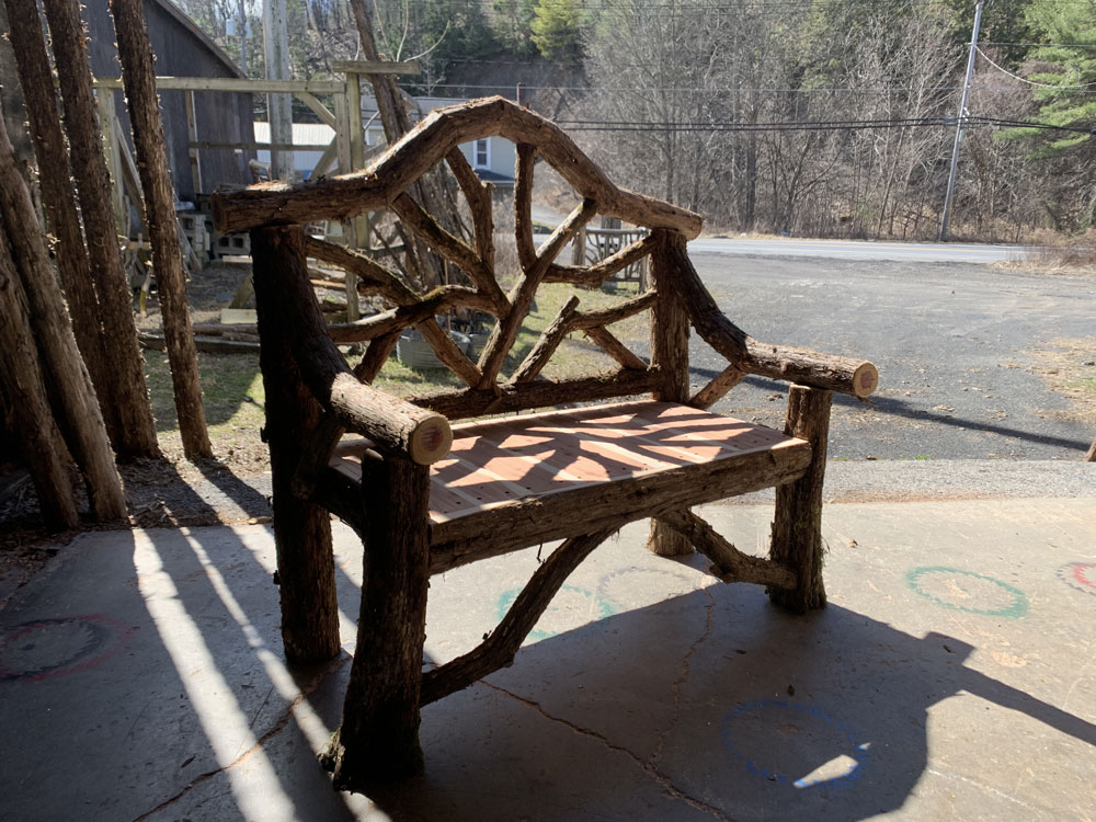 Natural wood bench built with trees and branches titled the Garrison Bench