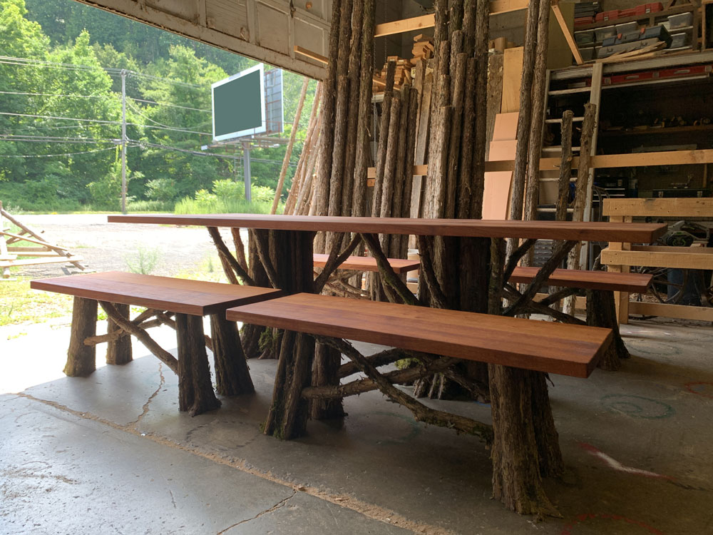 Outdoor rustic dining table and banches built using african mahagony and bark-on trees and branches titled the Healey Outdoor Dining Table