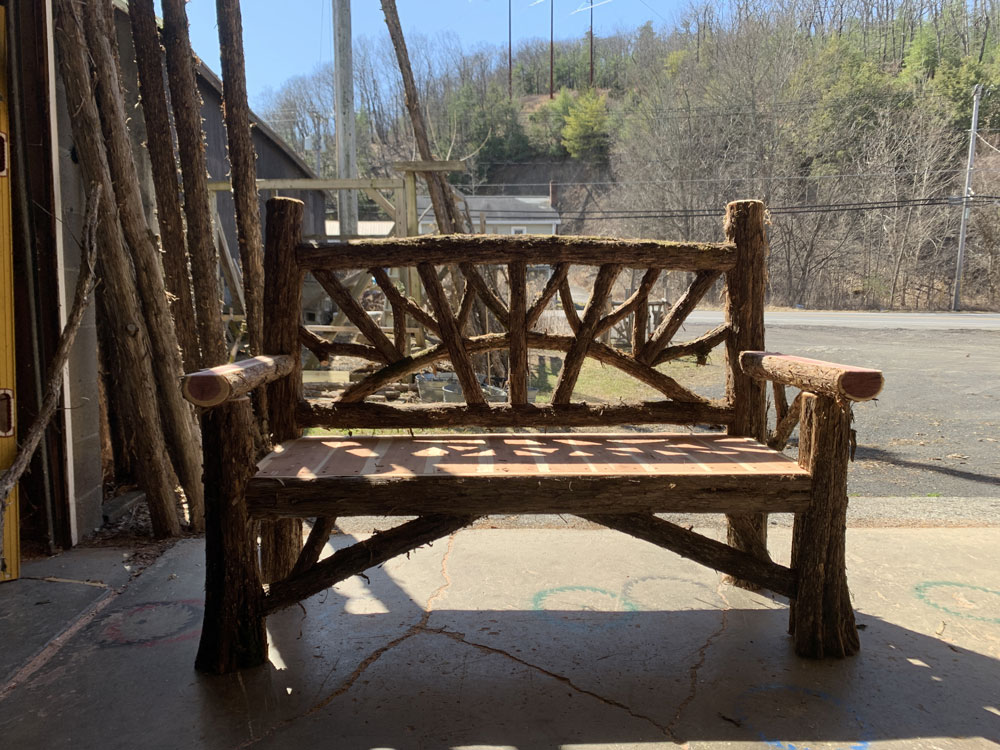 Exterior twig bench built from cedar logs titled the Maverick Bench