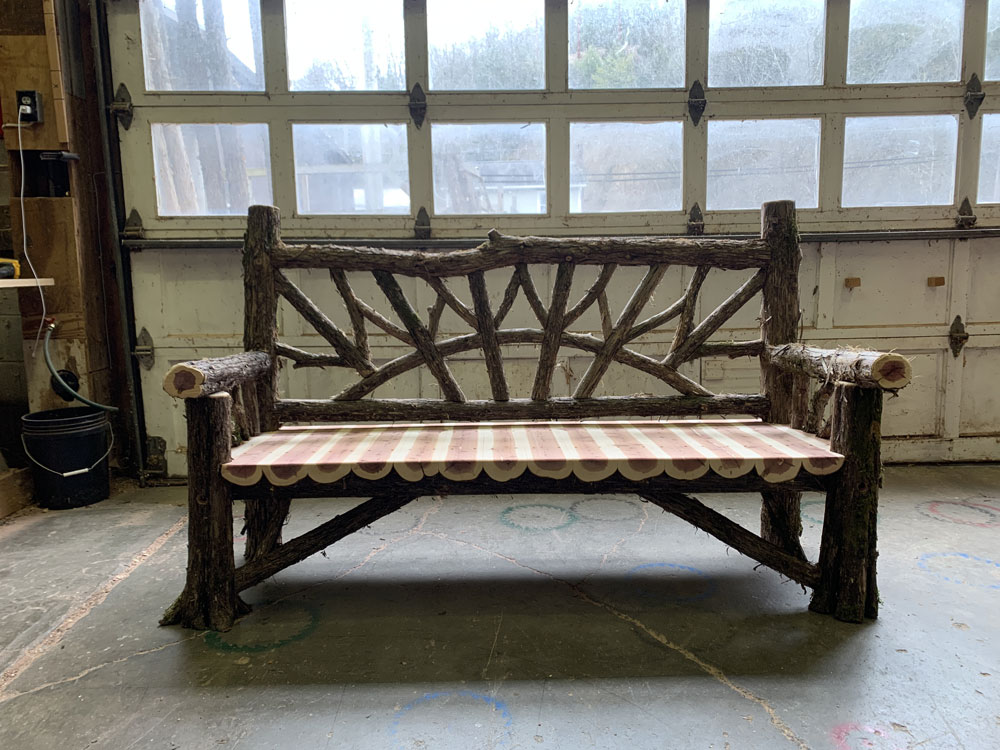 Natural wood bench built with trees and branches titled the Maverick Bench