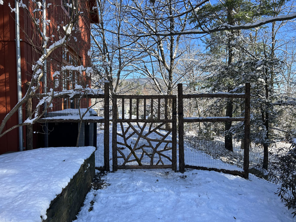 Rustic fence and gates built using bark-on trees and branches titled the McKenna Fence and Gate