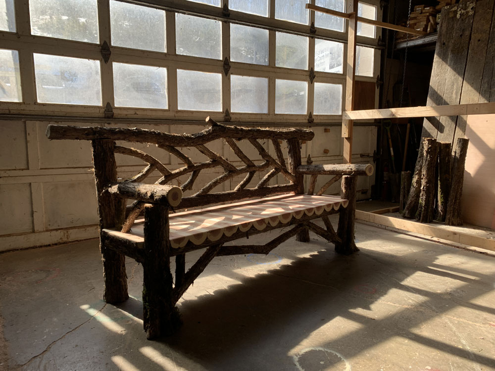 Exterior twig bench built from cedar logs titled the Rhinebeck Bench