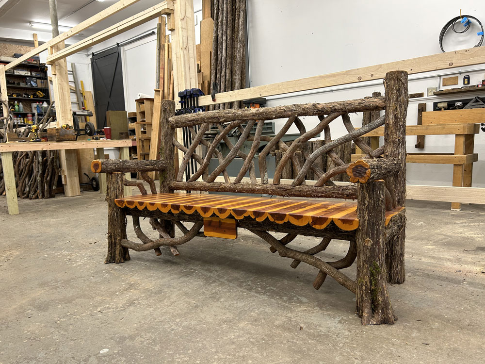 Natural wood bench built with trees and branches titled the Mohonk Bench