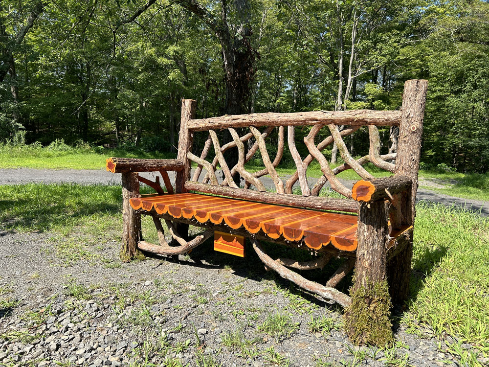Rustic bench custom built using cedar trees and branches titled the Mohonk Putnam Bench