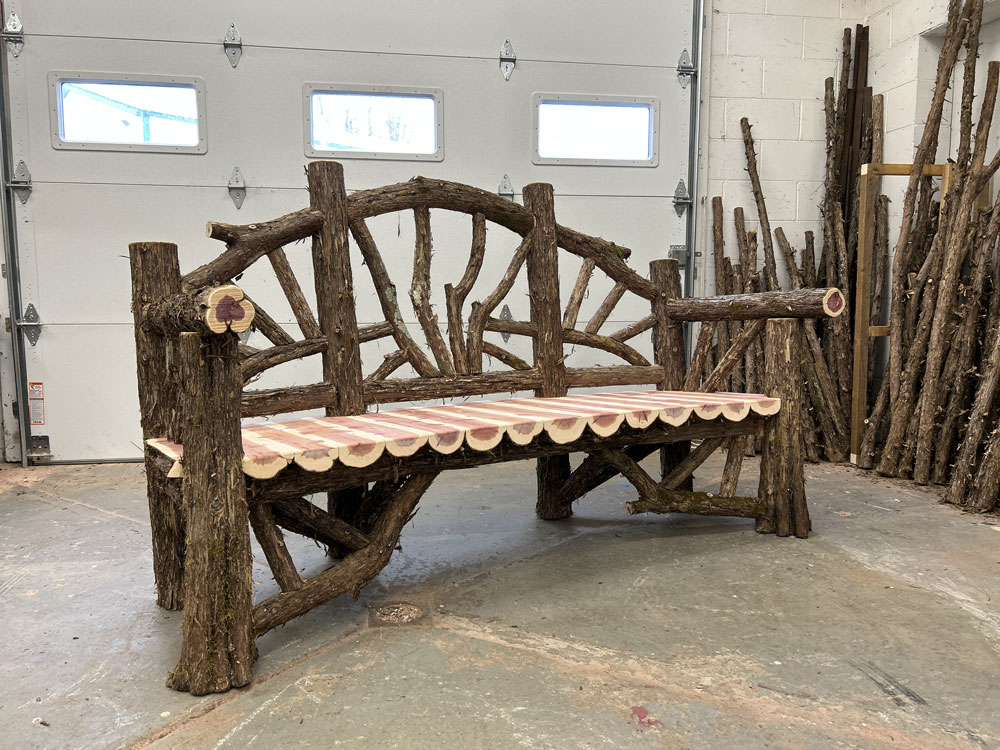 Natural wood bench built with trees and branches titled the Poets Bench
