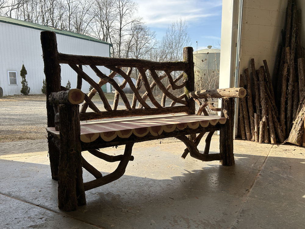 Exterior twig bench built from cedar logs titled the Putnam Bench