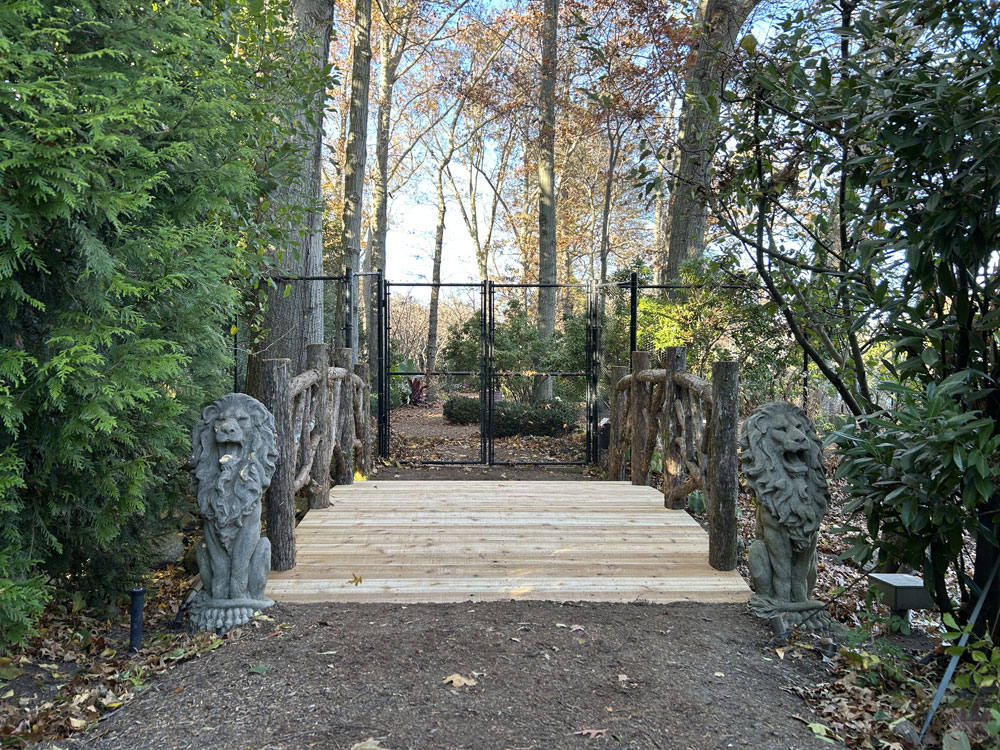Bridge built in the rustic style using logs and branches titled the Tyson Bridge