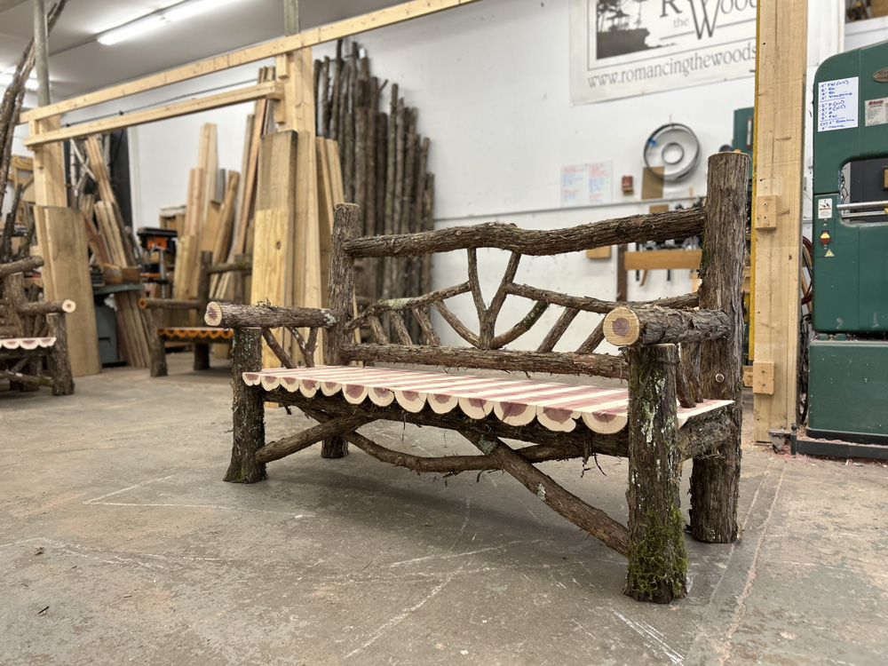 Outdoor rustic garden bench built using bark-on trees and branches titled the Haddem Bench