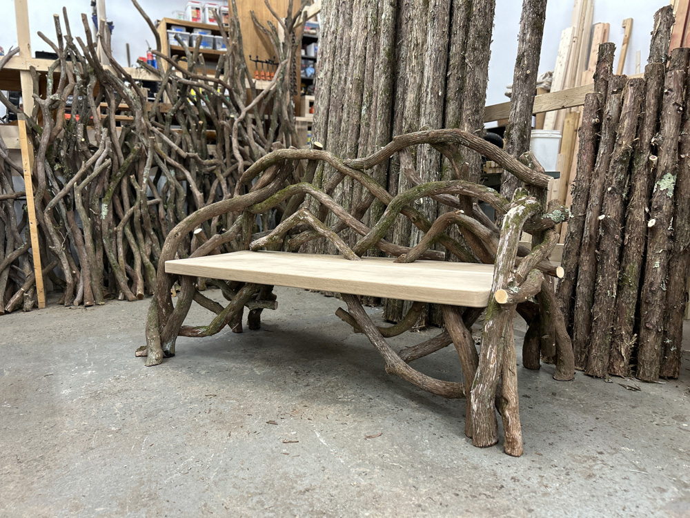 Outdoor rustic park bench built using mountain laurel trees and branches titled the Olana Bench