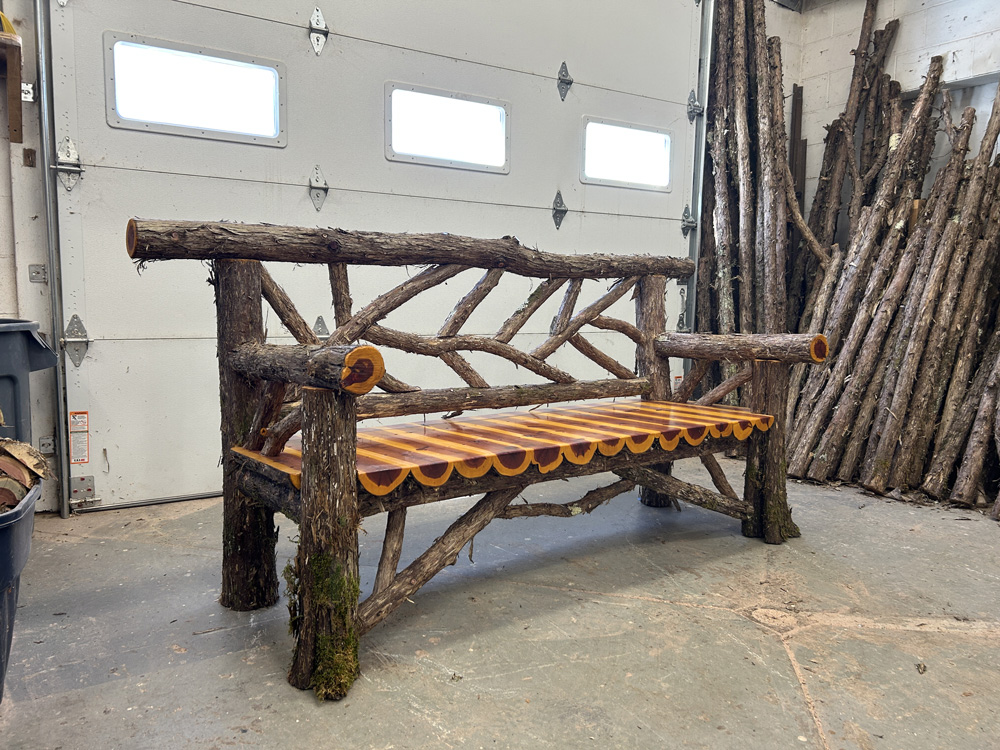 Outdoor park bench built in the rustic style using logs and branches titled the Rhinecliff Bench