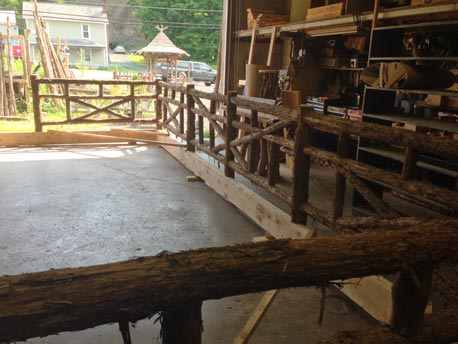 Rustic railings built using bark-on trees and branches titled the Plymouth Deck Railings
