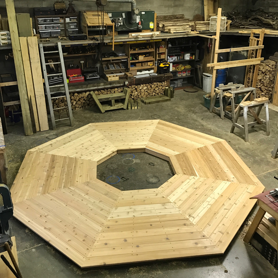 Rustic bench custom built around a tree constucted using cedar trees and branches titled the Skyview Tree Bench