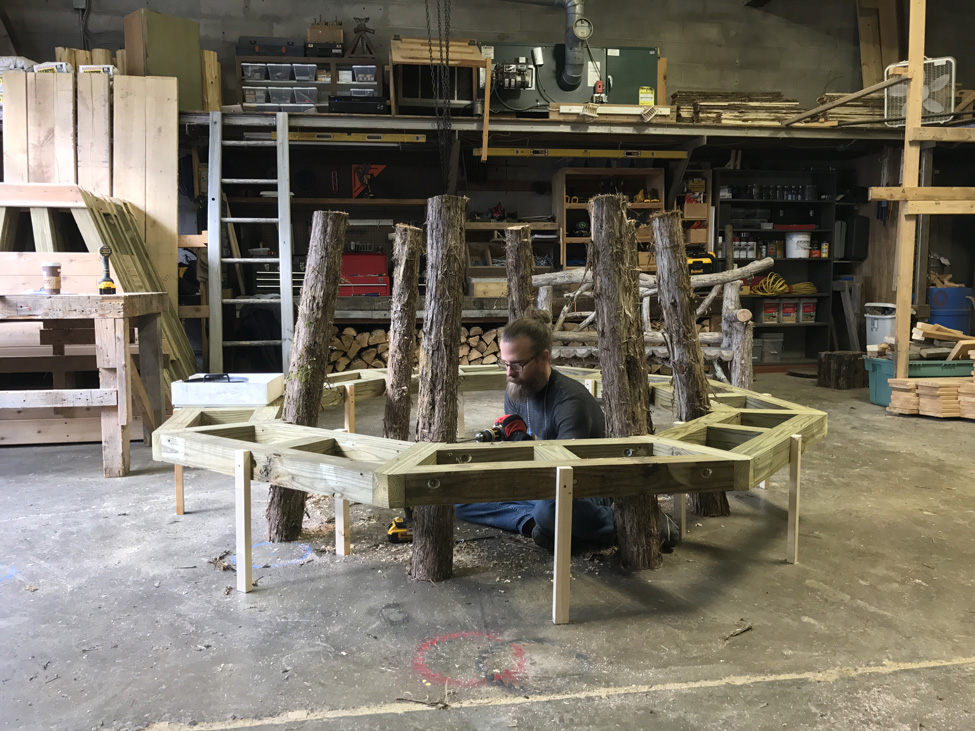 Rustic bench custom built around a tree constucted using cedar trees and branches titled the Skyview Tree Bench