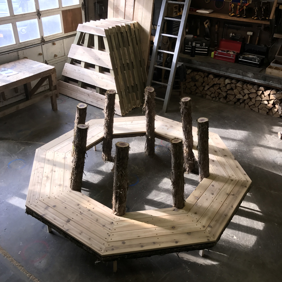 Outdoor park bench built in the rustic style using logs and branches titled the Skyview Tree Bench