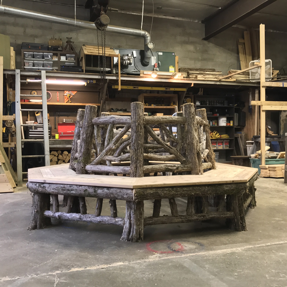 Rustic bench custom built around a tree constucted using cedar trees and branches titled the Skyview Tree Bench
