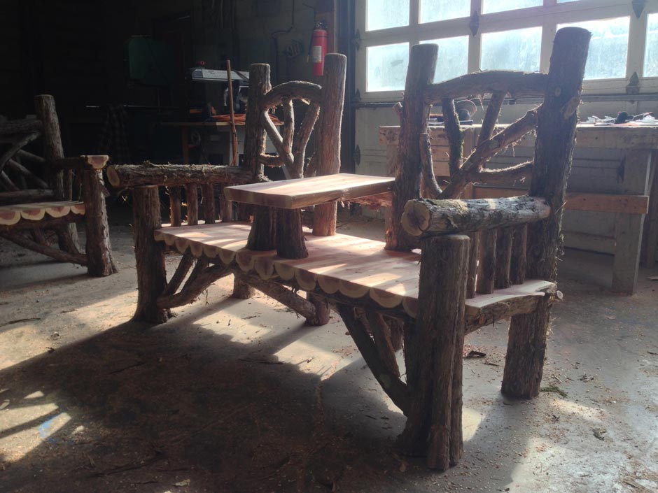 Outdoor rustic garden bench built using bark-on trees and branches titled the Midler Couple's Bench