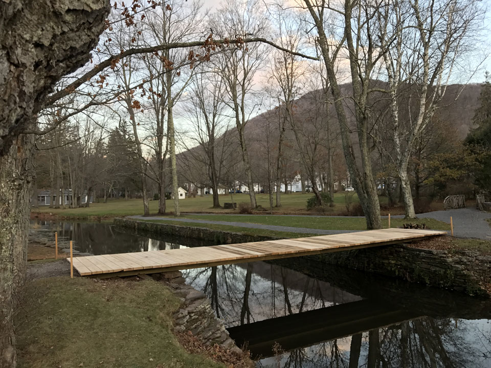 Natural wood bridge railings built with trees and branches titled the Kirkside Park Bridge 2016