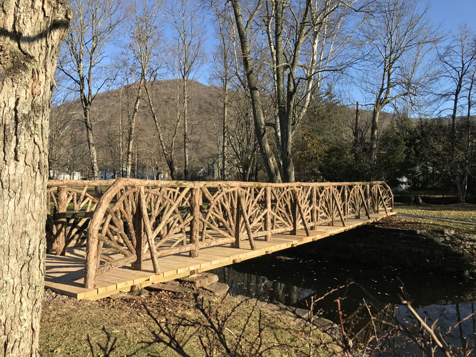Bridge railings built in the rustic style using logs and branches titled the Kirkside Park Bridge 2016