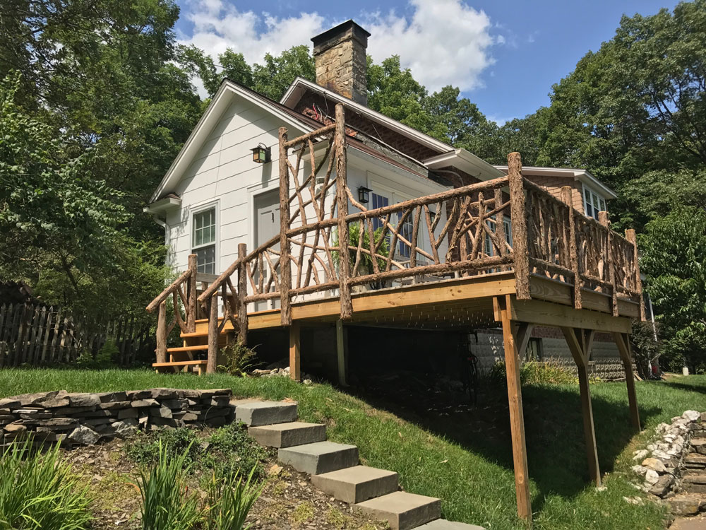 Rustic deck railings custom built using cedar trees and branches titled the Burroughs Deck Railings
