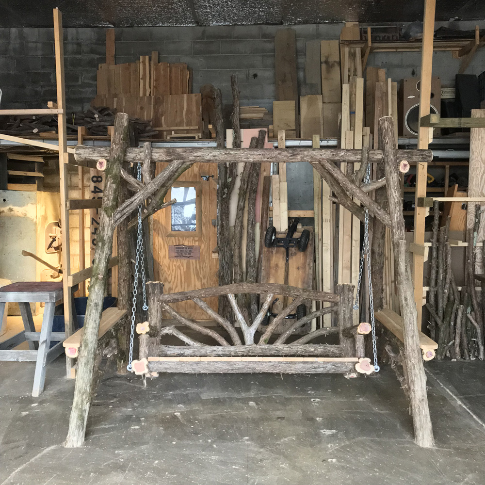 Exterior twig bench swing built from cedar logs titled the Bethany Bench Swing