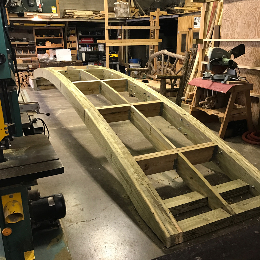 Rustic bridge custom built using cedar trees and branches titled the Storm's Crossing