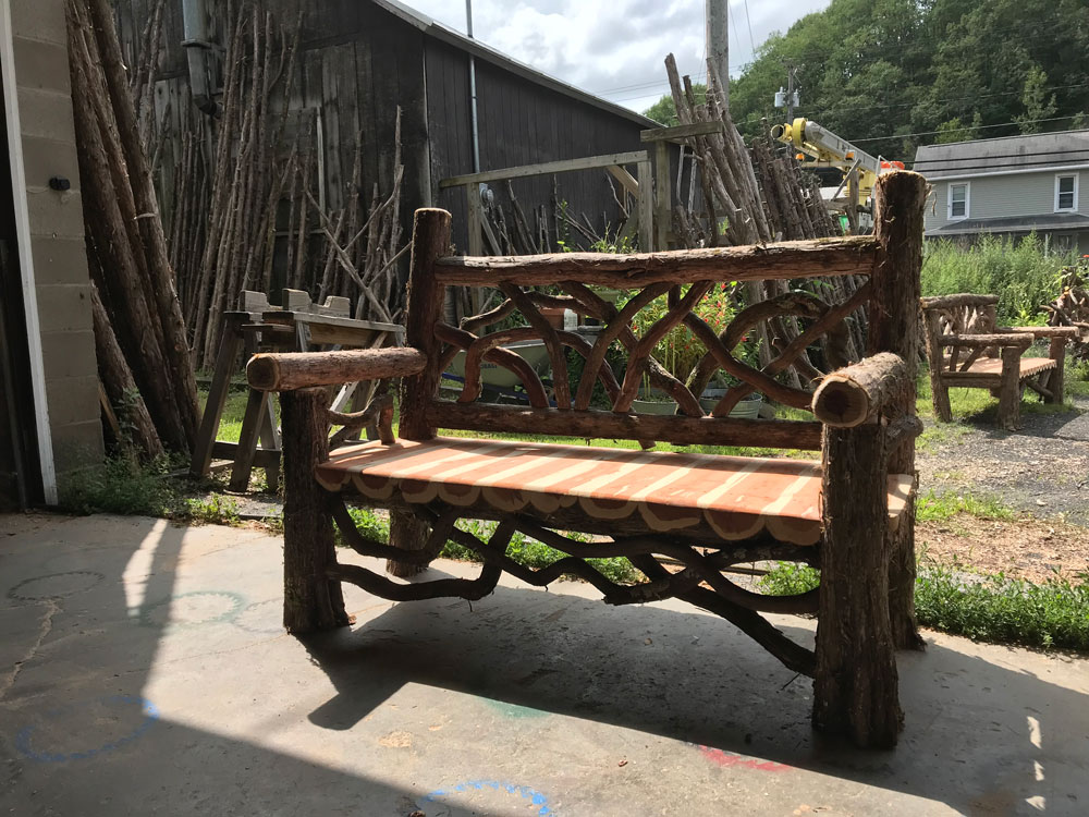 Natural wood bench built with trees and branches.