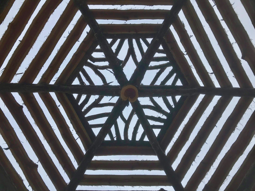 Rustic garden pavilion built using bark-on trees and branches titled the Fishers Island Gazebo
