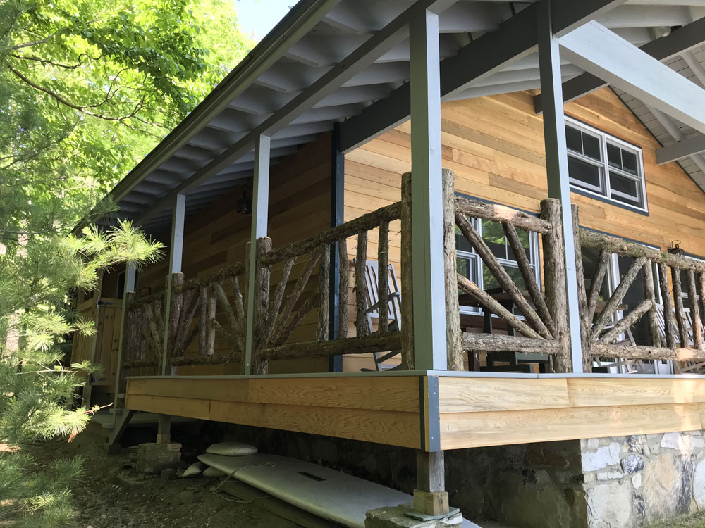 Rustic railings custom built using cedar trees and branches titled the Porch Railings at Hullets Landing