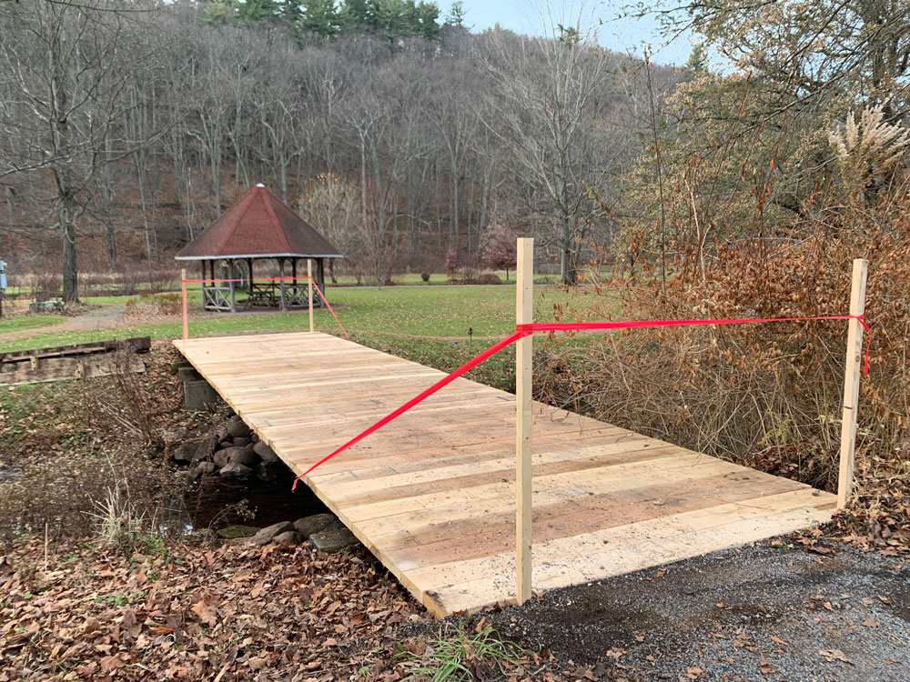 Rustic bridge railings custom built using cedar trees and branches titled the Kirkside Park Access Bridge