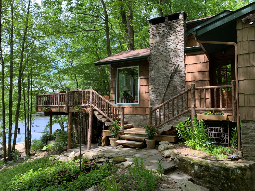 Rustic deck railings built using bark-on trees and branches titled the  Holmes Deck Railings