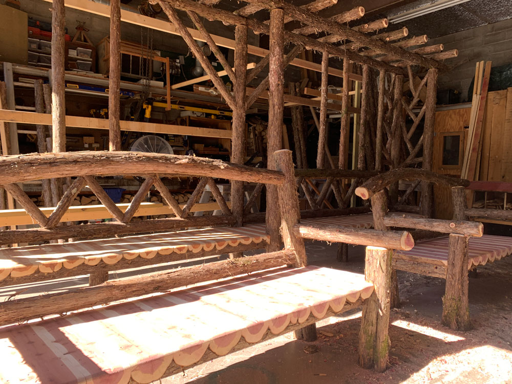 Natural wood bench built with trees and branches titled the Poet's Bench