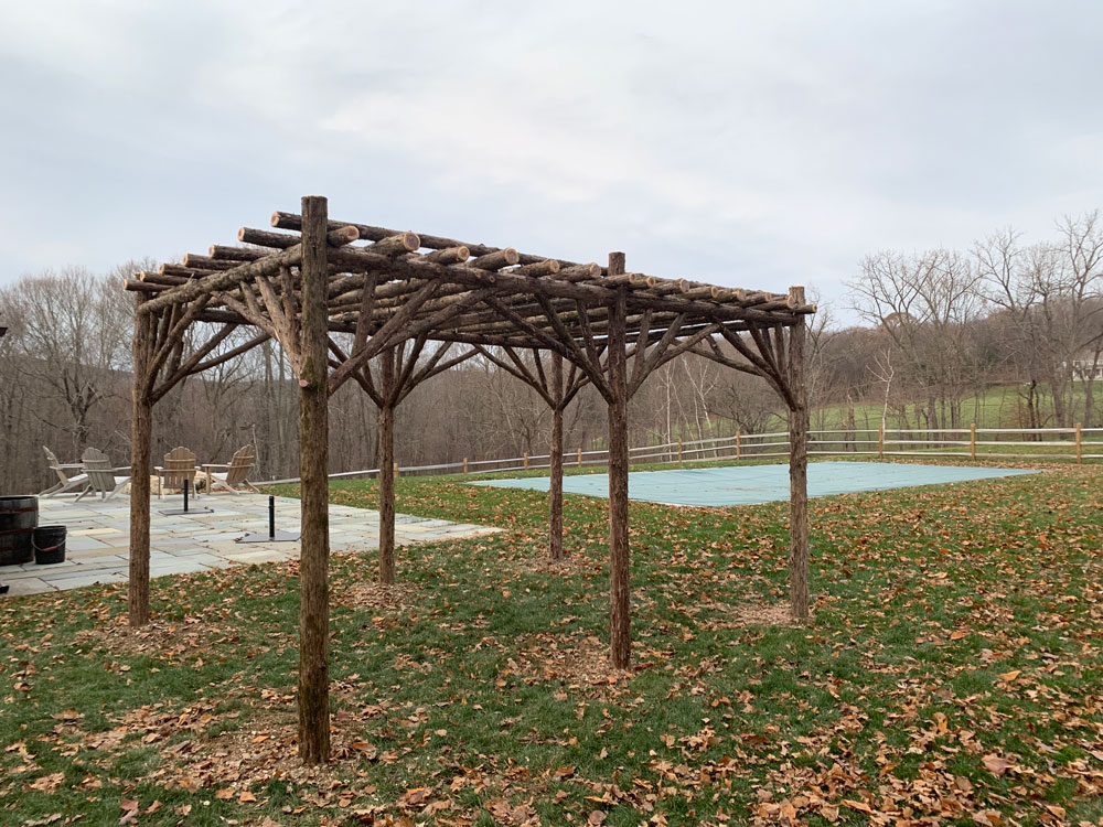 Branchwork rustic pergola constructed using natural materials titled the Pine Plains Pergola
