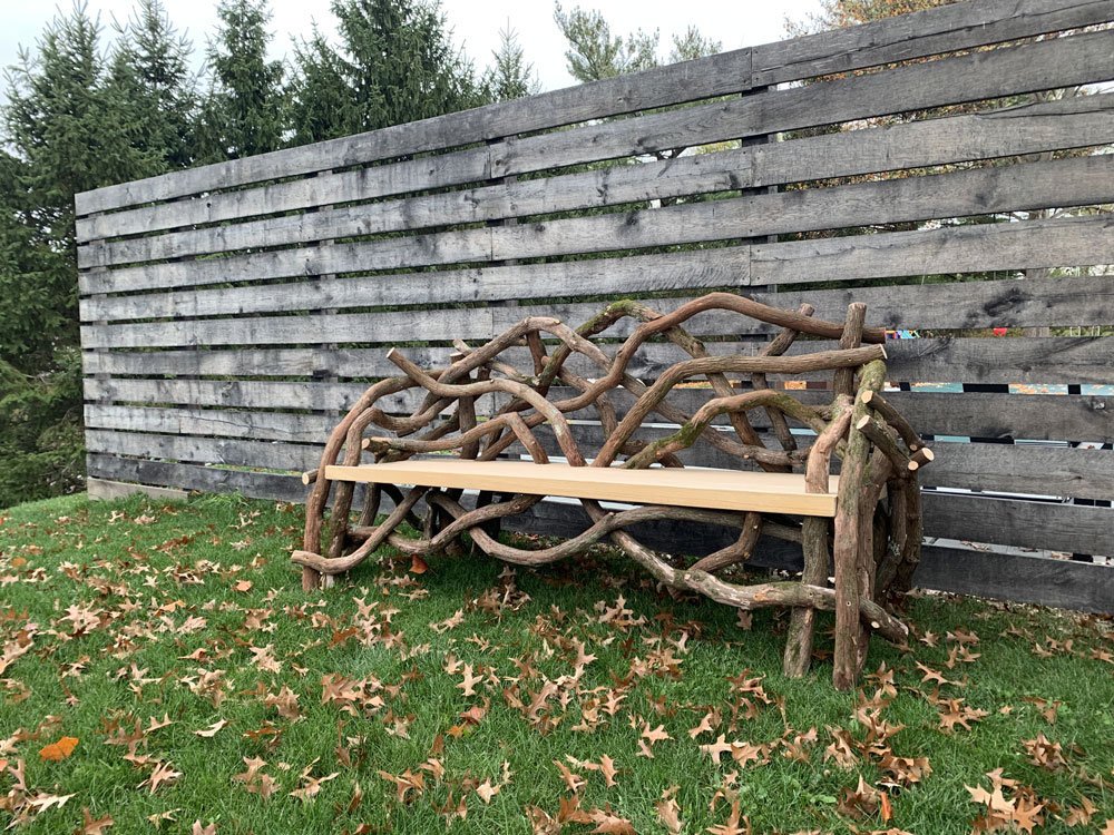 Outdoor rustic park bench built using mountain laurel trees and branches titled the Germantown Olana Benches