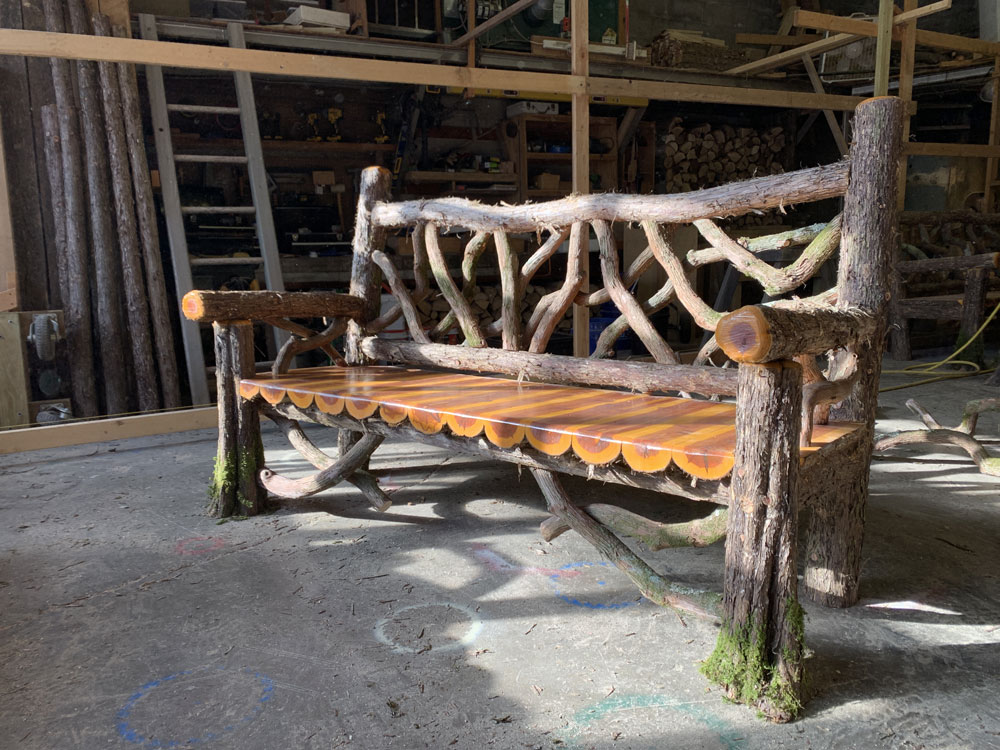 Exterior twig bench built from cedar logs titled the Mohonk Bench
