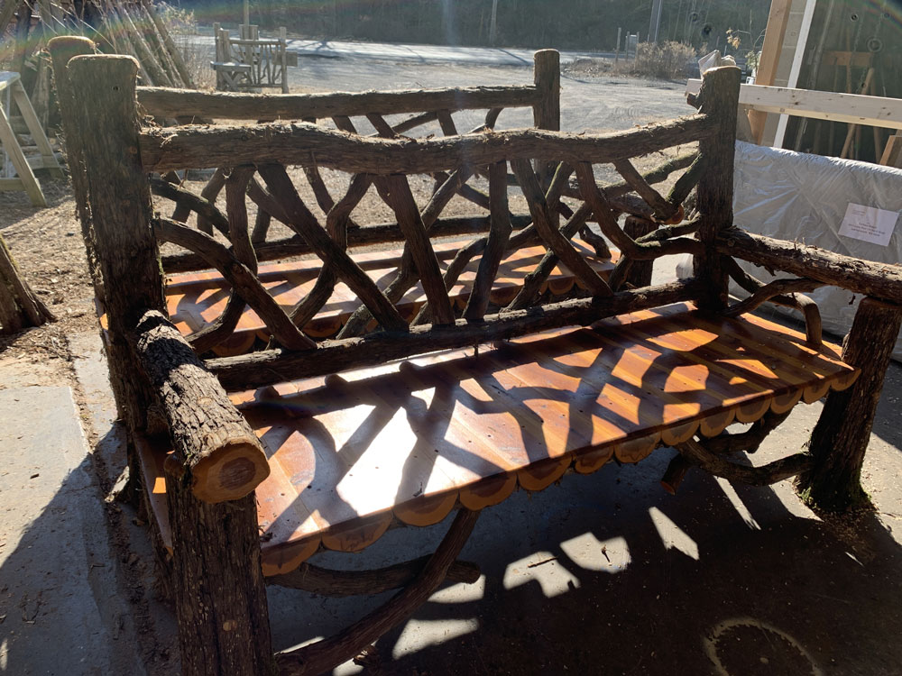 Outdoor rustic garden bench built using bark-on trees and branches titled the Mohonk Bench