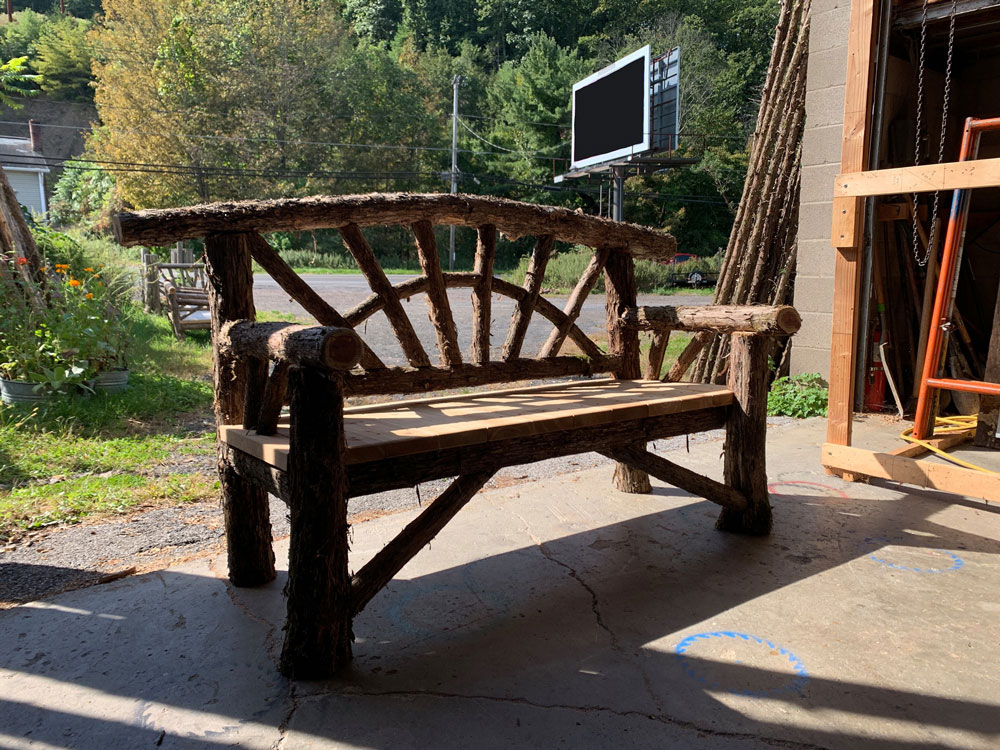 Natural wood bench built with trees and branches titled the Croton Bench