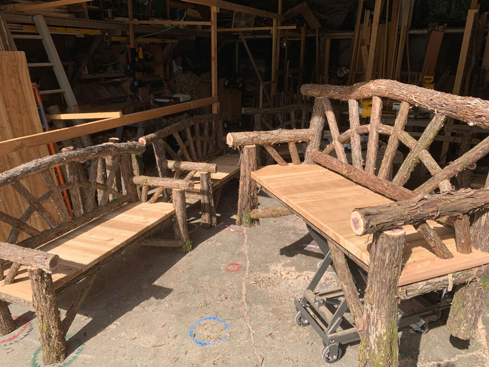 Outdoor rustic garden bench built using bark-on trees and branches titled the Croton Bench
