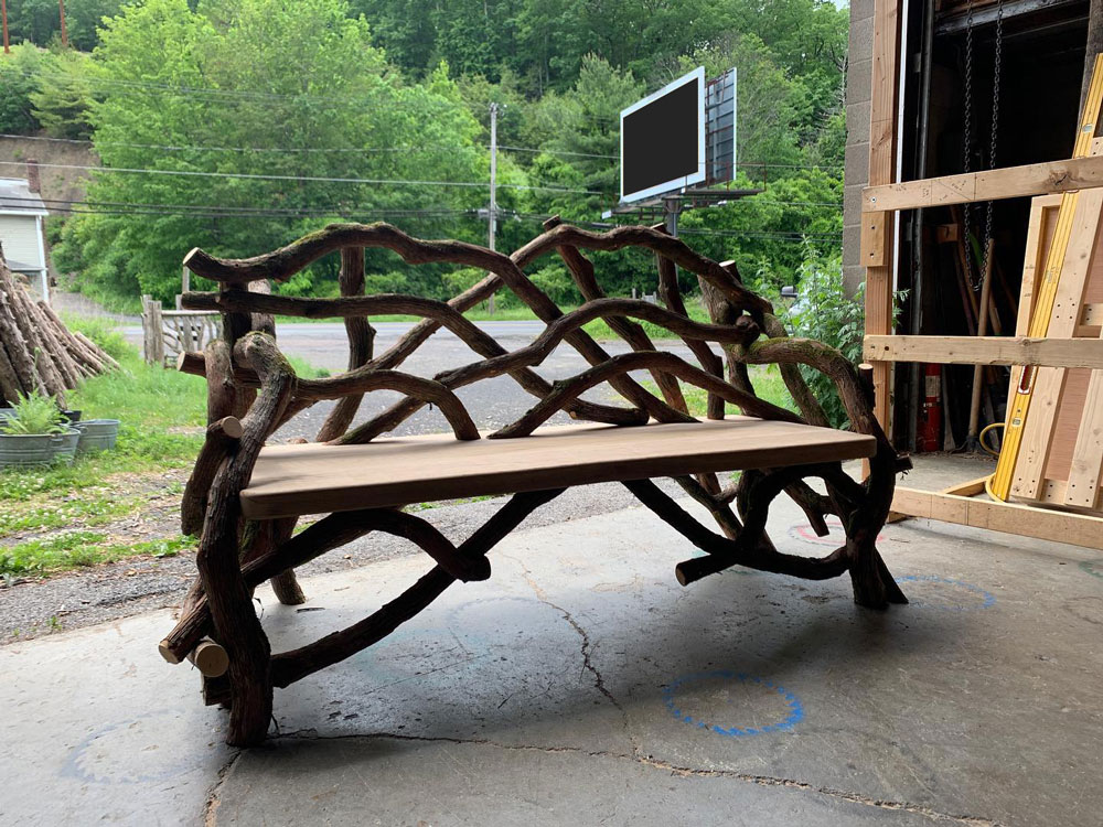 Outdoor rustic park bench built using mountain laurel trees and branches titled the Mountain Laurel Bench