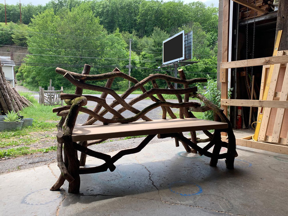 Outdoor rustic park bench built using mountain laurel trees and branches titled the Mountain Laurel Bench