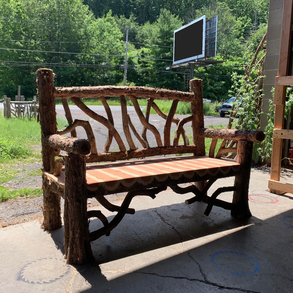 Rustic bench custom built using cedar trees and branches titled the Putnam Bench