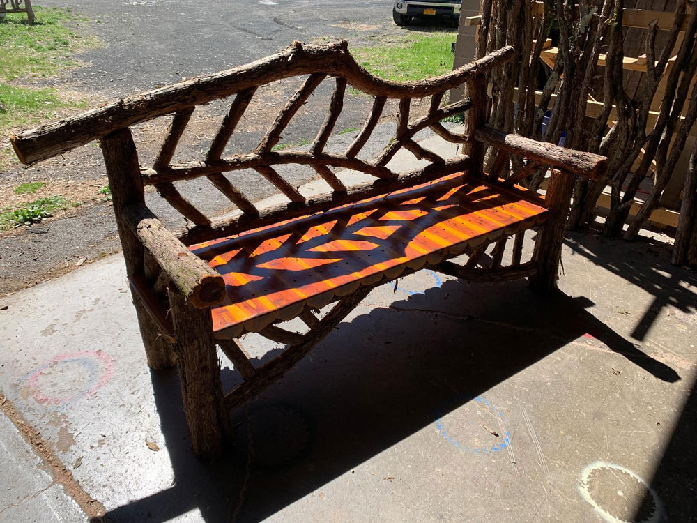 Rustic bench custom built using cedar trees and branches titled the Rhinebeck Bench