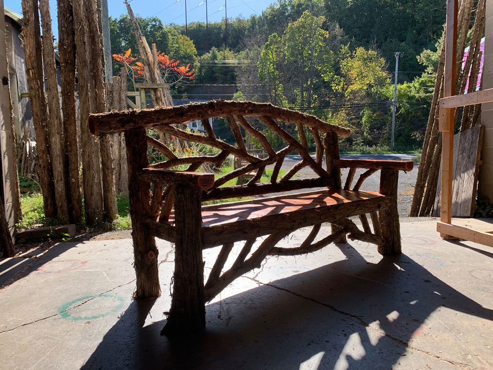 Outdoor rustic garden bench built using bark-on trees and branches titled the Rhinebeck Bench