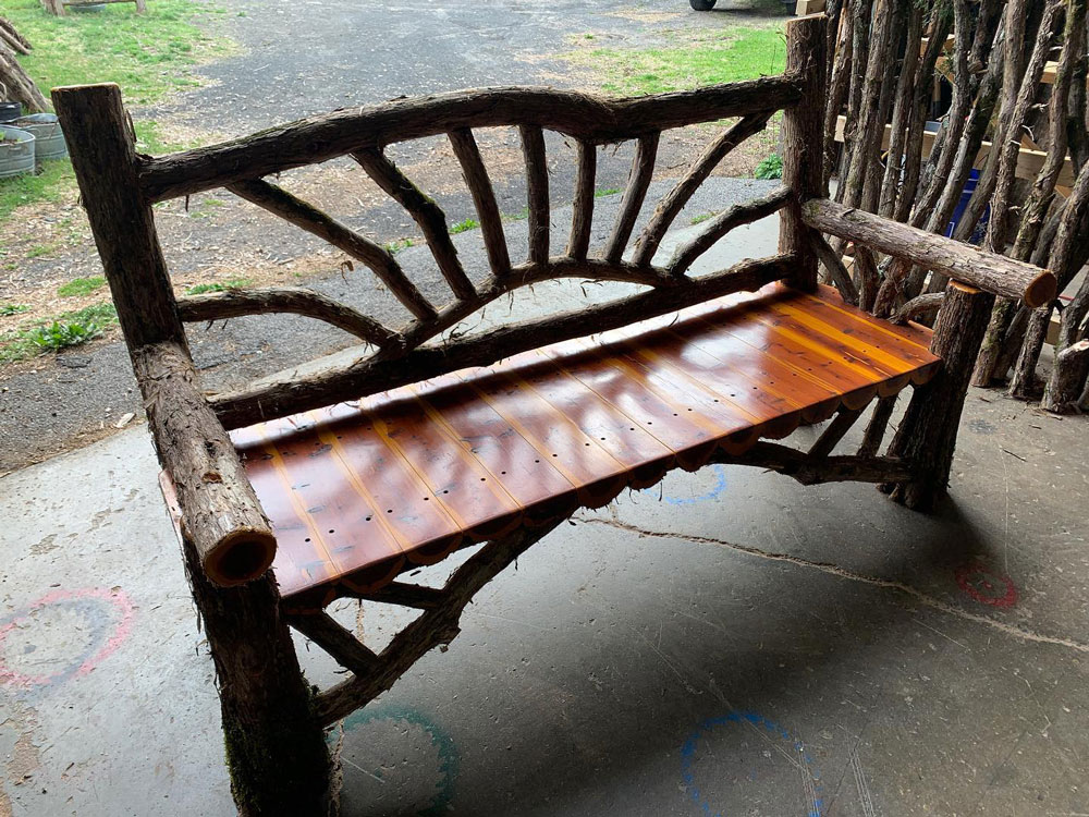 Natural wood bench built with trees and branches titled the Sunburst Bench