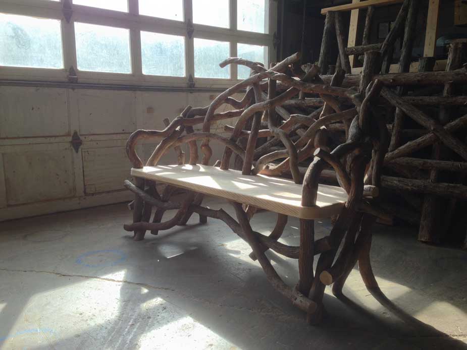 Outdoor rustic garden bench built using bark-on trees and branches titled the Heyl Bench