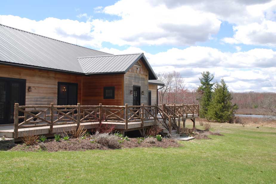 Railings built in the rustic style using logs and branches titled the Huguenot Deck Railings