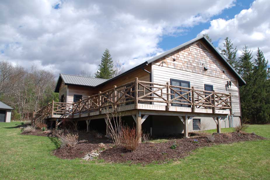 Natural wood railings built with trees and branches titled the Huguenot Deck Railings