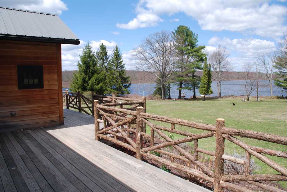 Natural wood railings built with trees and branches titled the Huguenot Deck Railings