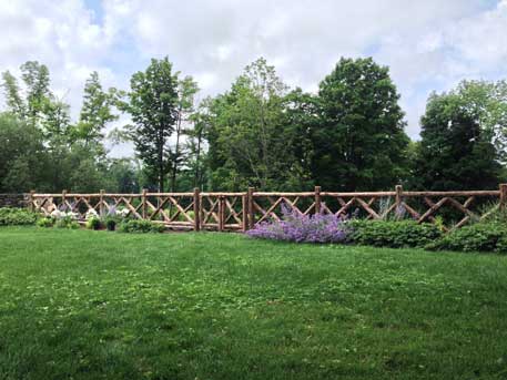 Natural wood fencing built with trees and branches titled the Old Chatham Fencing