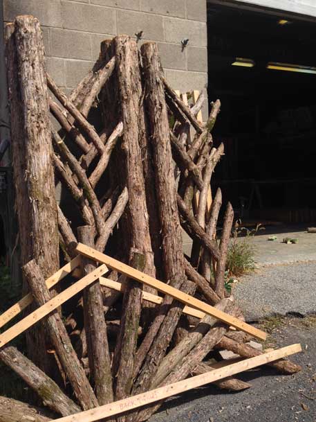 Rustic garden pavilion built using bark-on trees and branches titled the Martin Pavilion